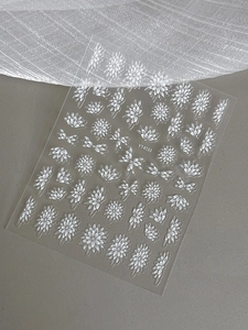 Macro detail of white floral nail decals featuring delicate daisy designs on transparent film