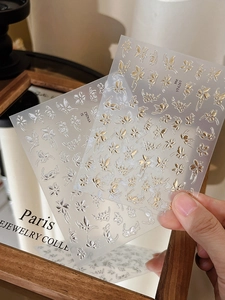Détail d'autocollants pour ongles avec papillons et fleurs en relief or et argent