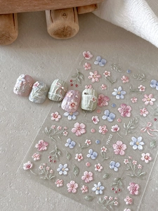 Close-up of 5D embossed floral nail stickers with colorful garden patterns and 3D textures