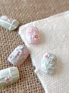 Macro detail of 3D embossed floral nail art stickers with oil painting texture and pearls