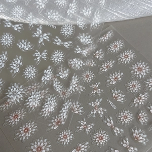 Translucent floral nail stickers with white and pink daisies on a transparent base