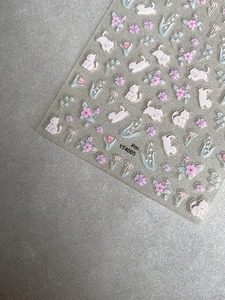 Macro detail of cute cartoon cat and pink flower nail stickers with YT4005 model text