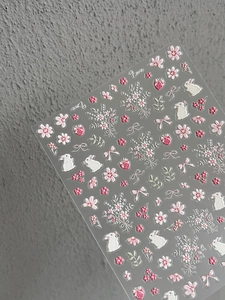 Macro shot of 3D embossed nail stickers featuring pink rabbits, sakura, and strawberry patterns