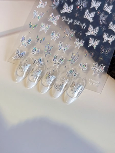 Macro view of holographic butterfly nail art stickers with iridescent shifting effects