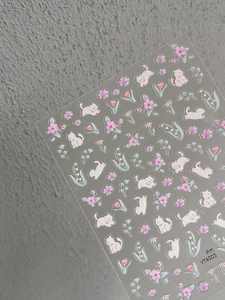 Detail of cute cat and flower nail stickers with transparent backing on grey background