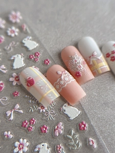 Detailed macro view of 3D embossed nail stickers featuring white rabbits and strawberries