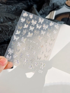 Close-up of holographic butterfly nail art stickers with shimmering starlight effect
