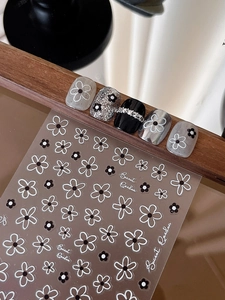 Detailed view of floral nail stickers with black and white hollow five-petal flowers