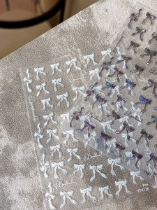 Macro detail of YT4129 holographic bowknot nail art stickers with laser ribbon patterns