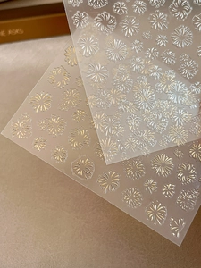 Macro detail of 3D embossed firework nail stickers in gold and silver finish