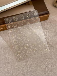 Detail of 3D gold fireworks nail art stickers showing intricate luxury foil patterns