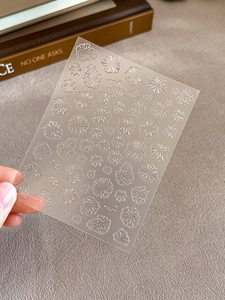 Macro detail of self-adhesive white daisy flower nail art stickers with frosted texture
