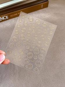 Detailed view of gold floral nail art stickers with elegant daisy motifs and gold foil finish
