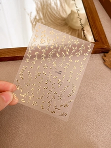 Detailed macro shot of gold foil leaf nail art stickers featuring the YT4098 floral design