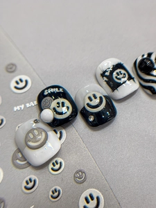 Macro detail of smiley face nail art stickers with pearls and sparkling rhinestones