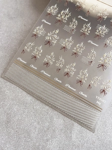 Détail macro des stickers ongles YT4140 avec nœuds dorés et motifs floraux délicats
