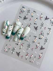 Gros plan d'autocollants 3D pour ongles avec fleurs blanches et papillons colorés