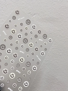 Detailed view of minimalist embossed nail stickers with grey and white smile patterns