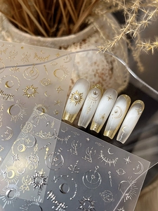 Detail of gold and silver celestial nail stickers with sun, moon, and star patterns