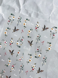 Détail de stickers nail art avec fleurs, papillons et accents dorés élégants