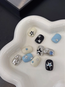 Detail of star pattern press-on nails with blue rhinestones and silver chrome finish