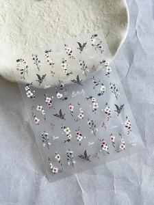 Détails macro d'autocollants pour ongles papillons et fleurs dorés sur fond texturé