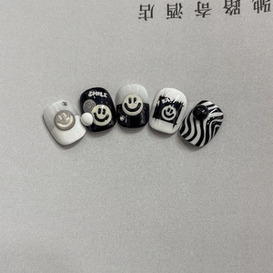 Minimalist black and white press-on nails featuring smile patterns and zebra stripes