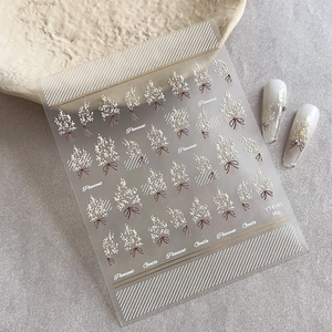 Autocollants d'ongles avec bouquets de fleurs blanches et nœuds papillons marrons