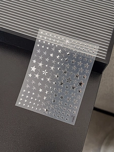 Detail of silver metallic star nail stickers with reflective finish and mini grid patterns