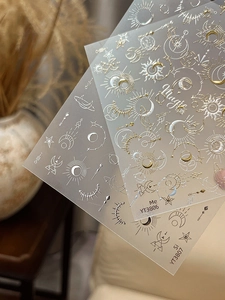 Detail of gold and silver nail stickers with magic sun, moon and star embossed designs