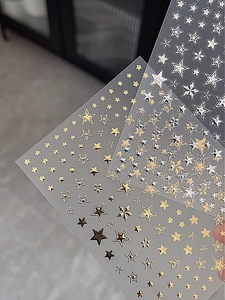 Detail view of gold and silver star nail stickers with reflective metallic finish and stars