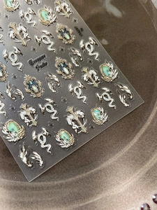 Detailansicht gotischer Nagelaufkleber mit Silberkreuzen und Smaragd-Edelstein-Motiven