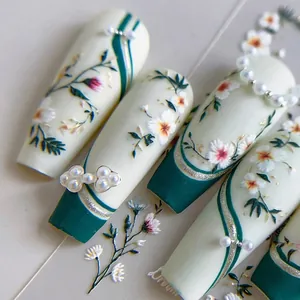 Faux ongles élégants vert émeraude et blanc ivoire avec motifs floraux et accents de perles