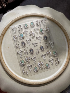 Makroaufnahme vintage Schlangen-Nagelaufkleber mit Silberstruktur und saphirblauen Steinen