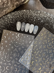Detailed view of gold and silver moon and star nail stickers with bohemian art patterns