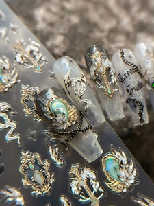 Nahaufnahme von 3D-Gothic-Nagelaufklebern mit Schlange und Kreuz in Metalloptik