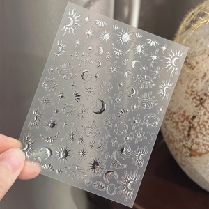 Silver celestial nail stickers featuring moon, stars, and mystic sun motifs on transparent base
