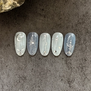 Blue marble press-on nails with silver celestial moon and star glitter decorations