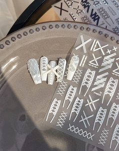 Detail of lace and rivet nail art stickers with 3D pearls and grid patterns for French style