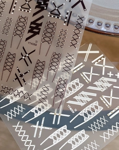 Detailed view of geometric lace and rivet nail stickers in black and white styles