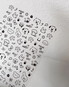 Close-up of minimalist black and white cartoon nail stickers featuring hand-drawn cute animals