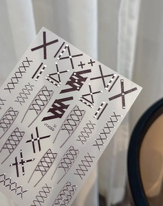 Detail of YT4060 nail sticker with black geometric X patterns and silver grid lines
