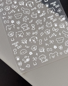 Detail of white hand-drawn cartoon nail stickers with bows and flowers on clear backing