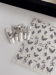 Detail of 3D embossed butterfly and hibiscus flower nail stickers on pearl nails