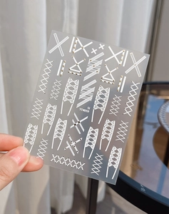 Macro detail of YT4059 lace and geometric nail decals featuring white cross strap patterns
