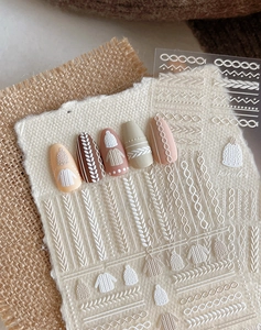 Vue macro des autocollants 3D pour ongles à motifs de tricot et pulls d'hiver