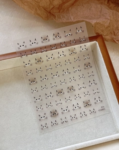 Dettaglio di adesivi nail art gatto carino con linee nere su uno sfondo strutturato