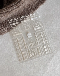 Vue détaillée des autocollants 5D pour ongles à motif de texture tricotée blanche