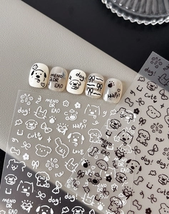 Detail of cartoon nail art stickers with black and white dog and bow designs
