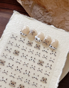 Dettaglio di adesivi per unghie a tema gatto e unghie finte con fiocco bianco 3D